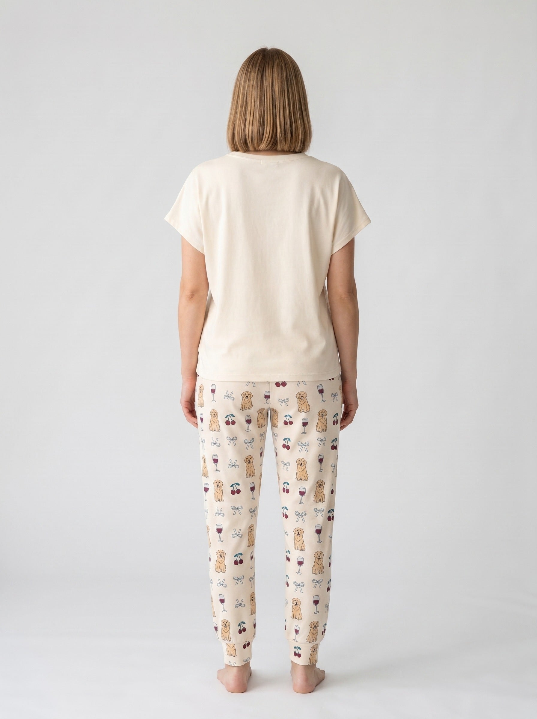 Cream soft knit pajama set with cartoon golden retriever Wine Not graphic tee and matching all-over print jogger pants